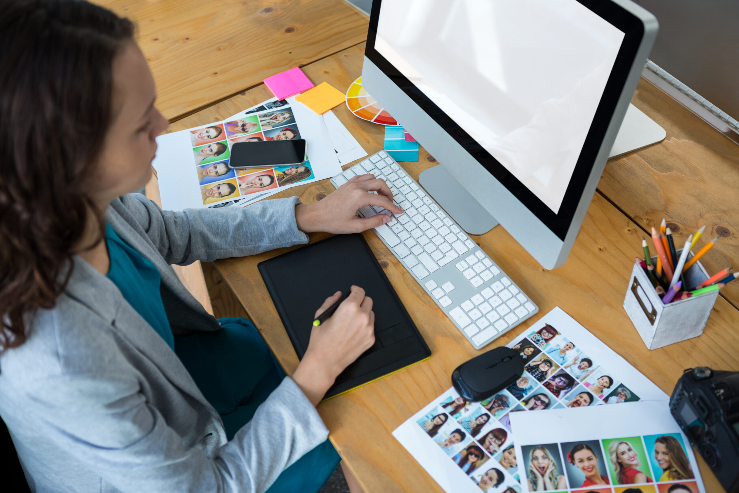 Female graphic designer using graphics tablet at desk in office