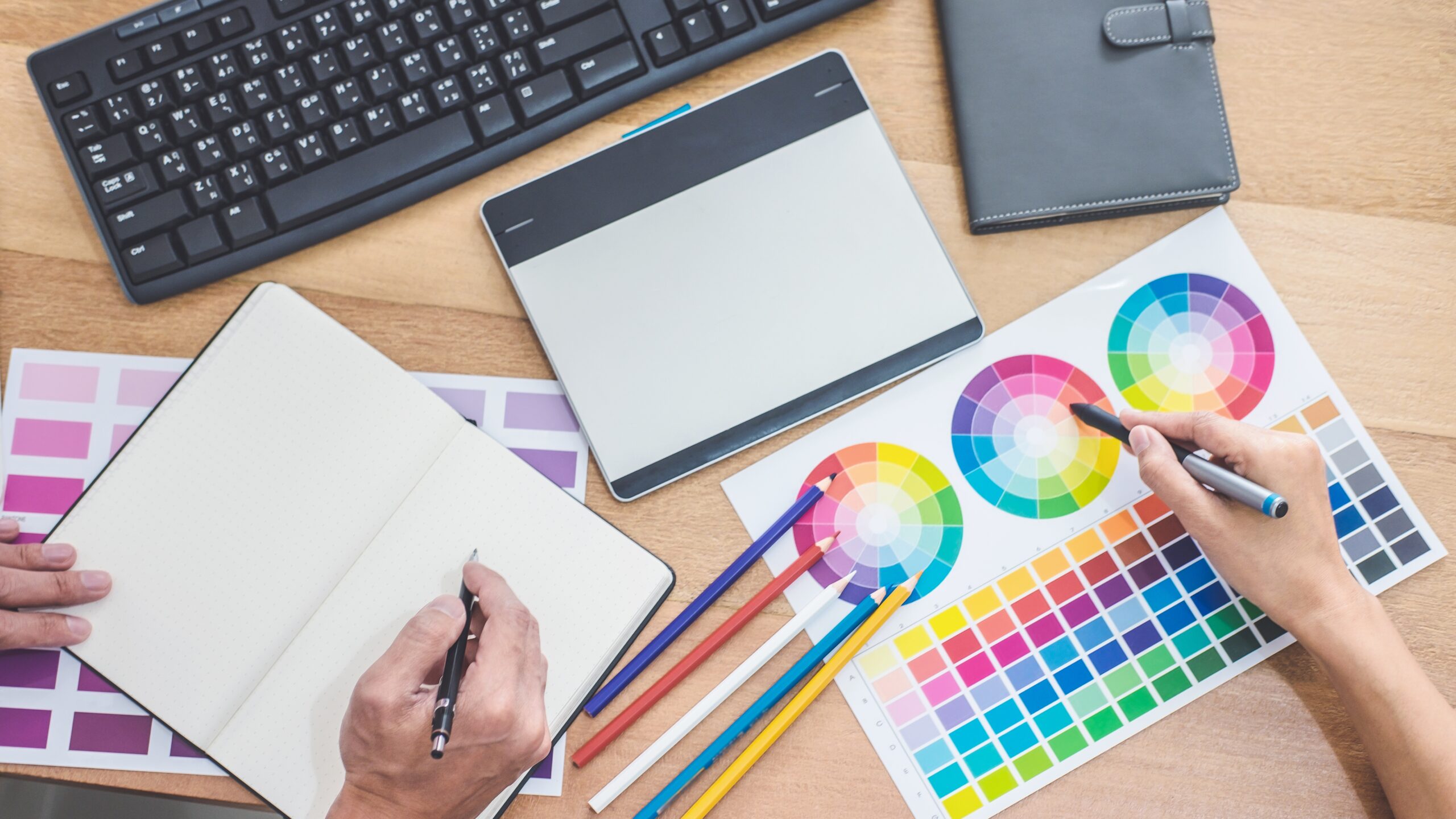 Two colleagues creative graphic designer working on color selection and drawing on graphics tablet at workplace, Color swatch samples chart for selection coloring.